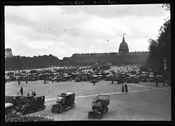 Numerous vehicles lined up in front of the Invalides dome.