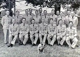 Formal portrait of Anderson seated with staff, students and bulldog mascot of the RAAF Staff School