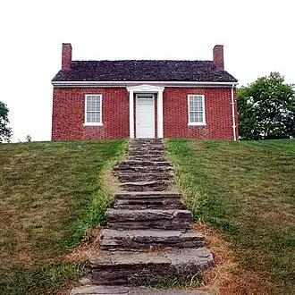 Stairs leading up to red-brick house on a hill