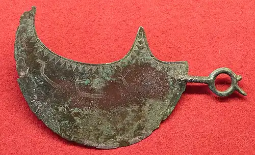 Lunar razor with engraved hunting scene, -9th-8th century, from the Villanovan necropolis of Vetulonia. Museo archeologico et d’arte della Maremma.