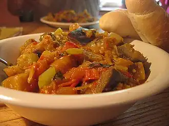 A bowl of ratatouille with bread