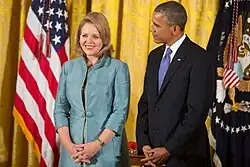 Fleming smiling, as Obama stands beside and looks to her