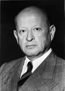 Portrait photograph of Robert Wartenberg wearing a suit against a dark background.