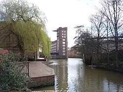Looking upstream from Foss Bridge to Rowntree Wharf, with Wormald's Cut to the right., 53°57′29″N 1°04′38″W﻿ / ﻿53.957975; -1.07725