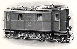 A short boxcab locomotive with only two driven axles. The single traction motor is hidden inside the body but drives via an intermediate jackshaft below the motor and between the wheels.