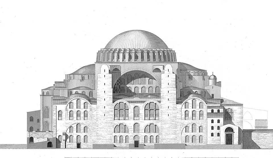 A reddish building topped by a large dome and surrounded by smaller domes and four towers