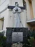 A statue of St. Pedro Bautista next to the original façade