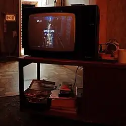 A photo of a television in a room with the screen showing "Acts of Faith" written over a street scene on it