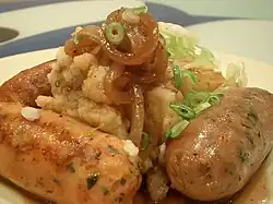 A plate of sausage and mashed potatoes, with cabbage and onion gravy, commonly known as "bangers and mash"
