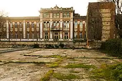 School building with a stone wall turret visible to the right.