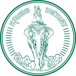 A round seal bearing the image of Indra riding Airavata among clouds, with the words "Krung Thep Maha Nakhon" (in Thai) across the top