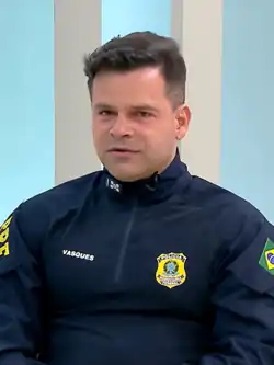 A police man is in uniform and looking at the camera.