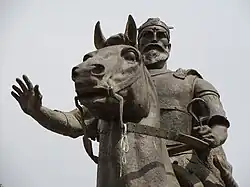 Skanderbeg with right hand raised in greeting pose