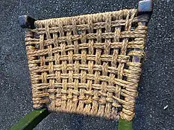 a cropped image looking down on the woven straw seat of a small Súgán chair