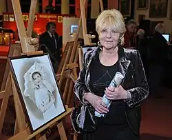 This person. Woman wearing a black outfit. Blonde hair.