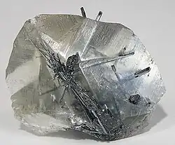 Needles of stibnite within a transparent crystal of calcite (size: 4.5×3.5×1.8&nbsp;cm)