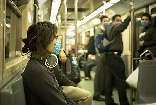 People on a subway wearing face masks.
