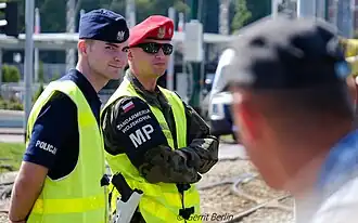 Soldier of the Polish Military Gendarmerie (right) displaying brassard, 2019.