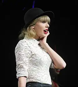 Swift in a laced Oxford shirt and black hat