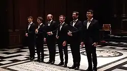 line-up of young men in black suits