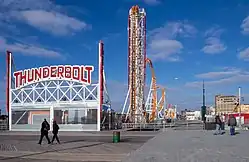 The Thunderbolt roller coaster at West 15th Street, a steel coaster painted orange with white supports