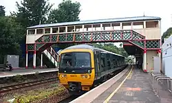 A green GWR train under the footbridge at Torre