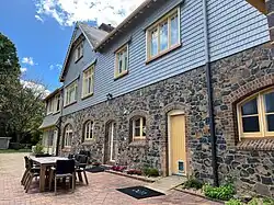 Clad in wood, painted blue, stonework on the lower half