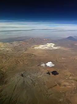 A landscape with mountains and a lonely cloud, seen from space