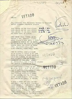 A document worn down by age with the lyrics and author information for the song. On the side, alongside serial numbers, there are several stamps reading "vetoed" in Portuguese.