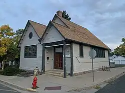 Picture of church, painted beige, with green trim, and a wooden door. This building is relatively small, probably about 1000&nbsp;ft.². Building is relatively old from the 1800s.