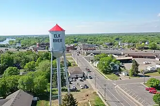 Aerial view of a metal water tower with a small cylindrical tank