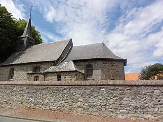 Photo of a small stone church under a blue sky with white clouds.