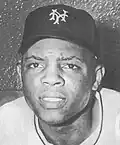 A black and white headshot of an African-American baseball player wearing a baseball cap with an interlocking 'NY'.