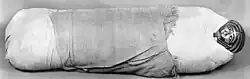 Cylinder-shaped mummy with small face mask