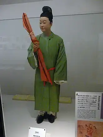 Contemporary men's dress, with green hō, white hakama, and kanmuri cap. This reconstruction is probably outdated; the hō should be shorter, with a short pleated frill beneath, as in the women's costume.[9]
